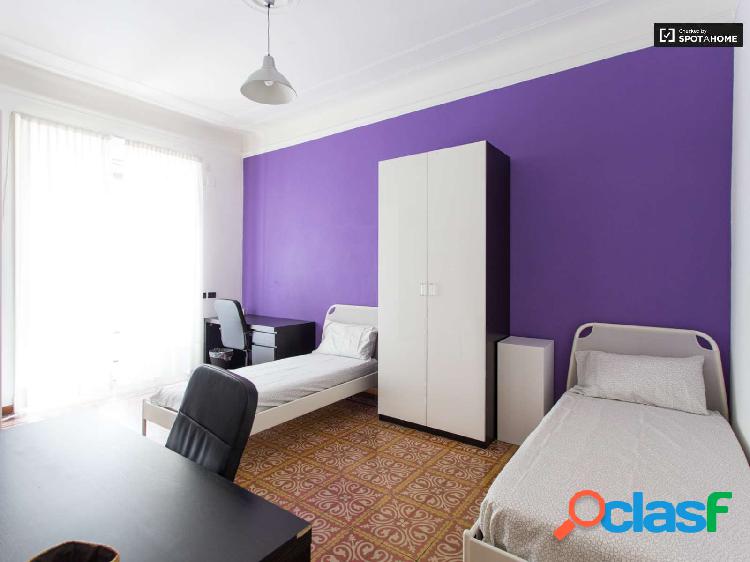 Cama en habitaci\xc3\xb3n colorida en apartamento con cocina